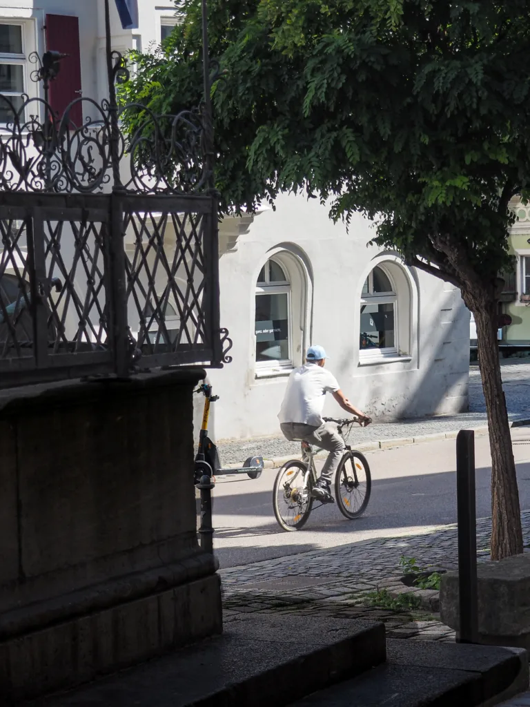 Kerékpáros a városban, napfényben.